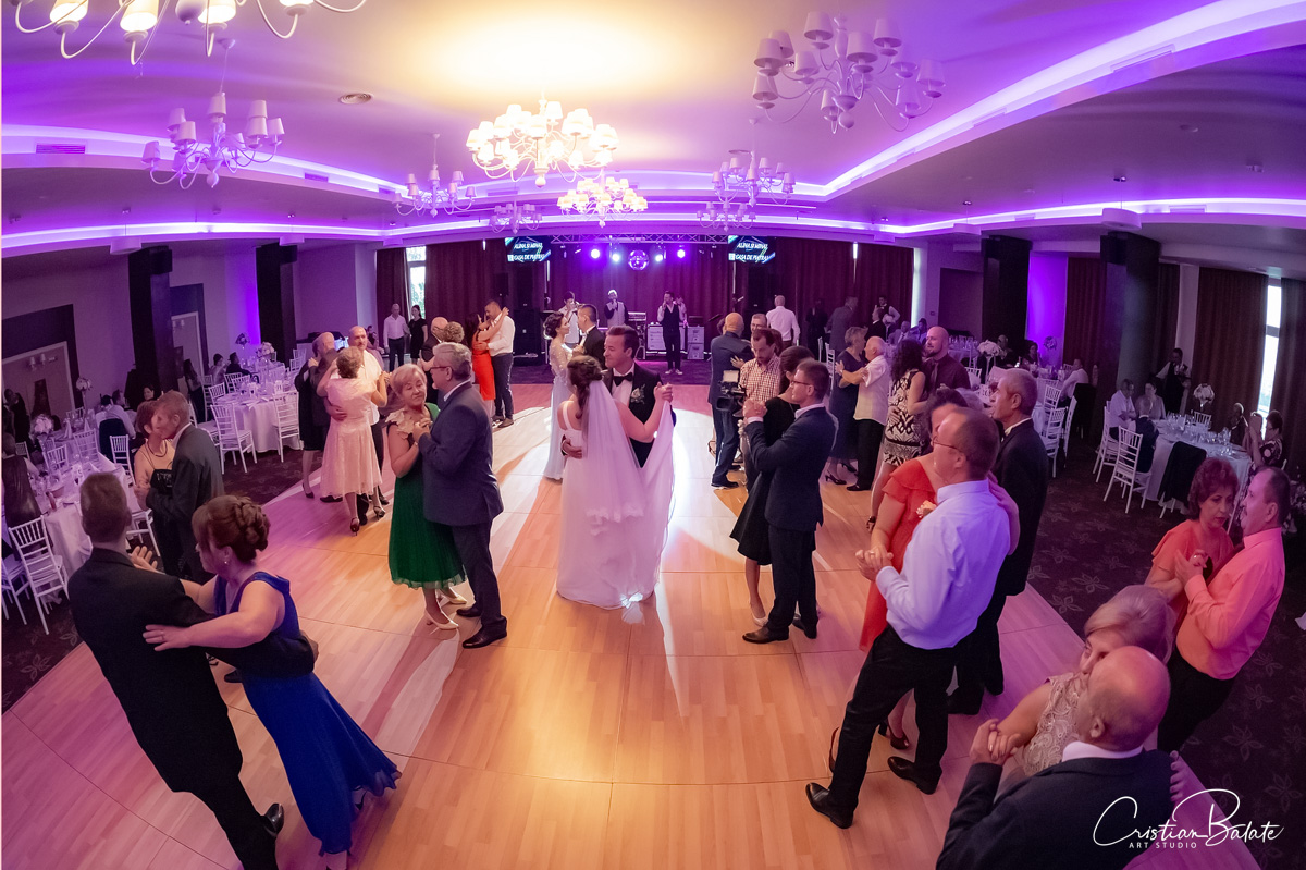 Wedding photography indoors at the party with the bride and the groom dancing together with the family and the quests